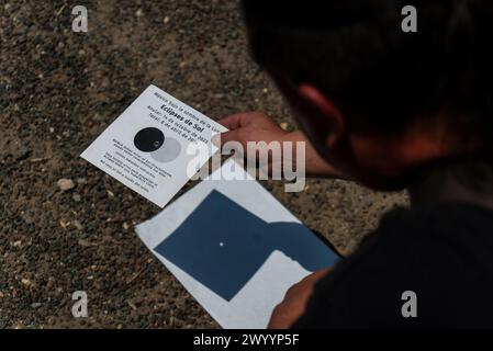 Mexiko Stadt, Messico. 8 aprile 2024. Un uomo tiene in mano una macchina fotografica durante un'eclissi solare. Milioni di persone in Messico, Stati Uniti e Canada hanno vissuto un'eclissi solare totale lunedì. Tale spettacolo celeste si verifica quando la luna passa tra il sole e la terra, coprendo completamente il sole. Crediti: Jair Cabrera Torres/dpa/Alamy Live News Foto Stock