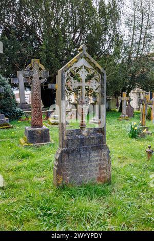 Croce scolpita in una lapide di pietra nel cimitero della chiesa parrocchiale di St Michael & All Angels a Mickleham, un villaggio vicino a Dorking, Surrey Foto Stock