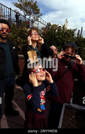 New York, New York, Stati Uniti. 8 aprile 2024. La gente sale su un tetto nella sezione Chelsea di Manhattan a New York per vedere l'eclissi solare che era visibile oggi sul Nord America e sul Canada. Crediti: Adam Stoltman/Alamy Live News Foto Stock