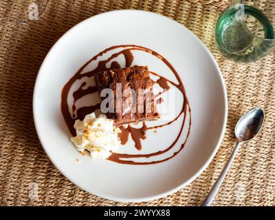 C'è un pezzo di torta al cioccolato marrone con salsa al cioccolato Foto Stock