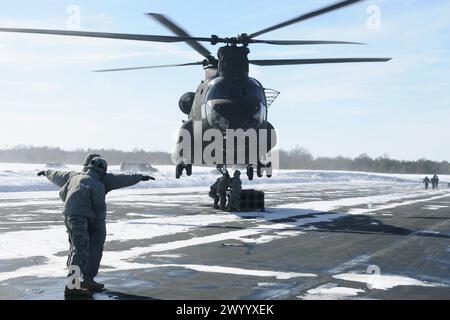 Gli studenti e il personale con il 89B munizioni Corso specialistico (ASC), insegnato dal XIII Battaglione, centesimo reggimento a Fort McCoy, Wis., partecipare a sling-operazioni di carico la formazione Marzo 5, 2014, a Sparta-Fort McCoy in aeroporto con un elicottero Chinook fornendo il supporto airlift. Gli studenti di ASC guadagnare la fornitura di munizioni badge specialista. Imbracare-operazioni di carico prevedono l'utilizzo di un elicottero come il Chinook per spostare i contenitori di munizioni da parte di aria. Il ASC sono stati gli studenti a imparare a collegare i contenitori di munizioni per un elicottero. (U.S. Foto dell'esercito da Scott T. Sturkol, Ufficio per gli affari pubblici, Fort Foto Stock