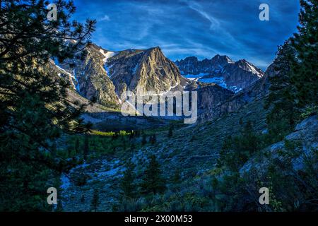 Una splendida e suggestiva scena di montagna innevata al crepuscolo in un primo giorno di primavera lungo il North Fork Trail a Bishop, California. Foto Stock