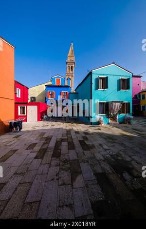 Case colorate, situate intorno ad una piazzetta dell'isola di Burano, il campanile pendente della chiesa di San Martino nel d Foto Stock