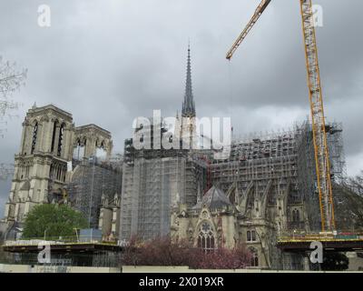 Parigi, Francia. 09 aprile 2024. Una gru si trova accanto a Notre-Dame circa cinque anni dopo il grande incendio che ha parzialmente distrutto la chiesa il 15 e 16 aprile 2019. La guglia e le facciate del transetto settentrionale e meridionale, così come la capriata del tetto, dovrebbero essere ampiamente restaurate al tempo delle Olimpiadi. Crediti: Sabine Glaubitz/dpa/Alamy Live News Foto Stock