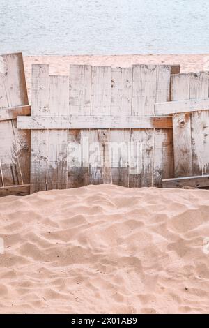 Recinzione in legno sulla spiaggia sabbiosa del Danubio, immagine verticale con messa a fuoco selettiva Foto Stock