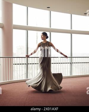 Donna, abiti eleganti e balli in corridoio, abbigliamento di moda e di classe nella hall per eventi. Donna, movimento a spirale e in raso o o lusso Foto Stock