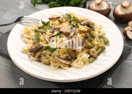 Pasta vegetariana con funghi, prezzemolo, fagioli e formaggio su un tavolo di legno grigio, primo piano Foto Stock