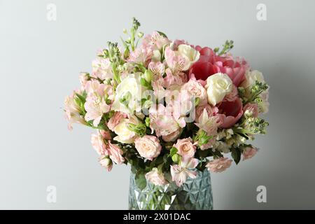 Bellissimo bouquet di fiori freschi in vaso su sfondo chiaro Foto Stock