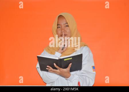 16 settembre 2023, foto di una donna musulmana che porta un libro, Wonosobo, Indonesia Foto Stock