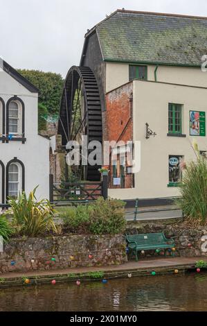 Una gigantesca ruota idraulica in ferro sulla parete delle sale da tè Old Mill in Brunswick Place, adiacente ai Dawlish Lawn Gardens a Dawlish, Devon, Inghilterra, Regno Unito. Foto Stock