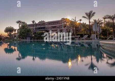 ASSUAN, EGITTO - 3 SETTEMBRE 2017: Lunga esposizione dello storico Old Cataract Hotel che si riflette nella piscina all'alba. Foto Stock