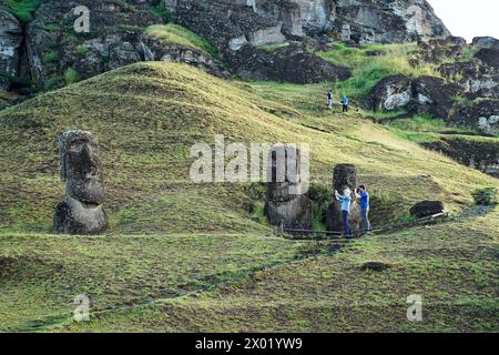 Isola di Pasqua. 5 aprile 2024. I turisti scattano foto delle statue di pietra di Moai sull'isola di Pasqua del Cile, 5 aprile 2024. L'Isola di Pasqua, conosciuta per le sue gigantesche teste scolpite in pietra che si affacciano sul mare, si trova nel punto più meridionale del Triangolo Polinesiano nel Pacifico meridionale ed è considerata una delle regioni abitate più remote del mondo. Crediti: Zhu Yubo/Xinhua/Alamy Live News Foto Stock