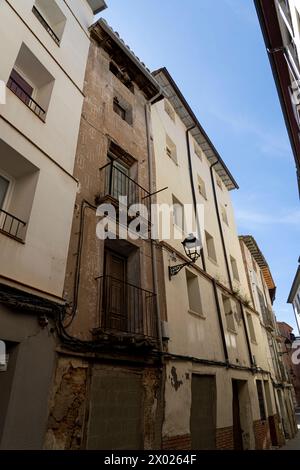 Un primo piano di un antico balcone con ringhiere ornate su un vecchio edificio urbano con pareti in angoscia Foto Stock
