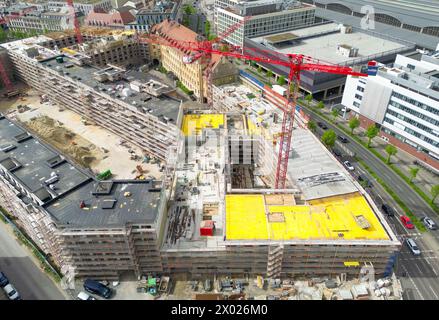 Lipsia, Germania. 09 aprile 2024. Nel cantiere di Krystallpalast si trovano diverse gru. Un nuovo complesso di edifici composto da quattro edifici a 4-6 piani e un cortile pubblico e' stato costruito su un terreno di circa 18.000 metri quadrati vicino al centro citta'. Sette associazioni immobiliari della Germania orientale hanno richiamato l'attenzione del governo federale sulla diversa situazione del mercato immobiliare rispetto al resto della Germania. (Vista aerea con drone) credito: Jan Woitas/dpa/Alamy Live News Foto Stock