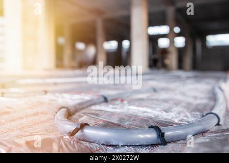 Installazione dei tubi sotto il pavimento per il riscaldamento dell'acqua: Miglioramento dei sistemi di riscaldamento con la tecnologia di riscaldamento a pavimento Foto Stock