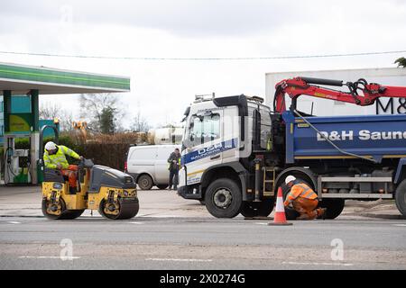 Denham, Regno Unito. 4 aprile 2024. Gli appaltatori stavano riempiendo buche su una strada principale a Denham, nel Buckinghamshire oggi. La strada è utilizzata dai camion di trasporto HS2 e spesso contiene grandi buche. In seguito alla cancellazione della tratta HS2 Northern Leg, il governo utilizzerà il denaro che sarebbe stato speso per il progetto High Speed Rail per migliorare le strade in tutto il Regno Unito. Crediti: Maureen McLean/Alamy Foto Stock