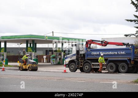 Denham, Regno Unito. 4 aprile 2024. Gli appaltatori stavano riempiendo buche su una strada principale a Denham, nel Buckinghamshire oggi. La strada è utilizzata dai camion di trasporto HS2 e spesso contiene grandi buche. In seguito alla cancellazione della tratta HS2 Northern Leg, il governo utilizzerà il denaro che sarebbe stato speso per il progetto High Speed Rail per migliorare le strade in tutto il Regno Unito. Crediti: Maureen McLean/Alamy Foto Stock