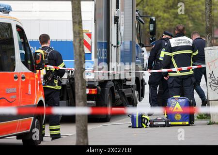 Amburgo, Germania. 09 aprile 2024. I servizi di emergenza e un veicolo di defusers della polizia di Amburgo si trovano di fronte ad una filiale della Postbank ad Amburgo-Lurup durante un'operazione. Martedì mattina, una filiale della Postbank nel Lurup-Center di Amburgo e le strade circostanti sono state chiuse e sono state chiamate squadre di smaltimento di esplosivi. Credito: Bodo Marks/dpa/Alamy Live News Foto Stock