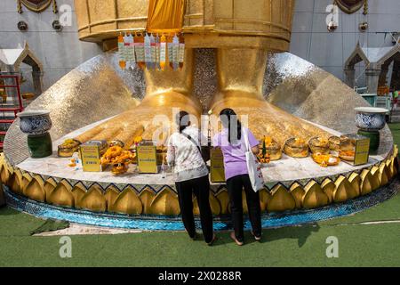 I piedi del Buddha d'oro di Wat Intharawihan a Thewet, nella città di Bangkok in Thailandia. Thailand, Bangkok, Dezember, 9, 2023 Foto Stock