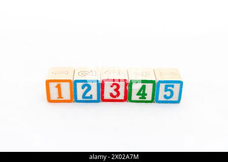 Fila di blocchi da costruzione giocattolo con numeri da 1 a 5 isolati su sfondo bianco. Foto Stock
