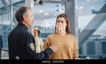 Terminal dell'aeroporto: L'addetto alla sicurezza controlla e separa diversi gruppi di persone che camminano attraverso i cancelli degli scanner per rivelatori di metalli per l'imbarco di volo in aereo. Affollato di viaggiatori che si recano in vacanza Foto Stock