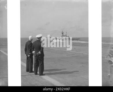 FORZA H OPERAZIONI NEL MEDITERRANEO. 1942, A BORDO DELLA PORTAEREI HMS ARGUS. - Il capitano della HMS ARGUS, il capitano G T Philips, DSO, RN, osservando la HMS EAGLE e la HMS MALAYA dal ponte di volo Royal Navy, EAGLE (HMS), portaerei (1918) Foto Stock