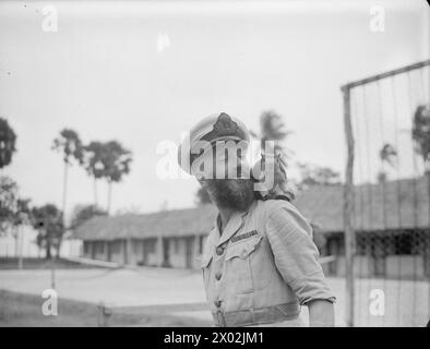 MOMENTI TROPICALI. 7 E 8 AGOSTO 1945, HMS RAJALYIA, ROYAL NAVAL AIR STATION PUTTALAM, CEYLON. ATTIVITÀ E PERSONALITÀ ALLA ROYAL NAVAL AIR STATION. - L'ufficiale barbuto della Marina che ha domato uno scoiattolo di roccia selvatica fino a quando non poserà per il cameraman è Lieut C Harrison, RNVR, di Stockport, Cheshire Foto Stock