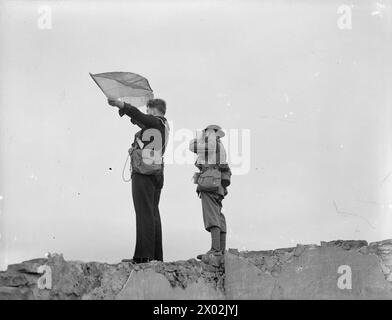 CON I ROYAL MARINES A TERRA E A GALLA. 1940, A BORDO DELLA HMS RODNEY E A TERRA. I VARI COMPITI SVOLTI DAI ROYAL MARINES. - Il capitano dei Marines segue i segnali della HMS RODNEY Foto Stock