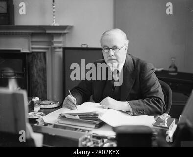 PERSONALITÀ POLITICHE BRITANNICHE 1936-1945 - Neville Chamberlain War Cabinet 3 settembre 1939 - 10 maggio 1940: Sir Kingsley Wood, Segretario di Stato per l'aria dal settembre 1939 all'aprile 1940, seduto alla sua scrivania presso il Ministero dell'aria Kingsley Wood, Howard Foto Stock