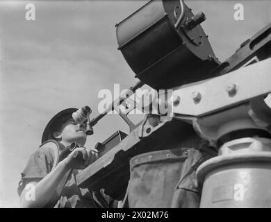 UOMINI DELLA CORVETTE BRITANNICA, HMS VERVAIN, IN SERVIZIO ATTIVO. 9-10 LUGLIO 1942. - Un pistolero ha visto maneggiare la pistola antiaerea Oerlikon Foto Stock