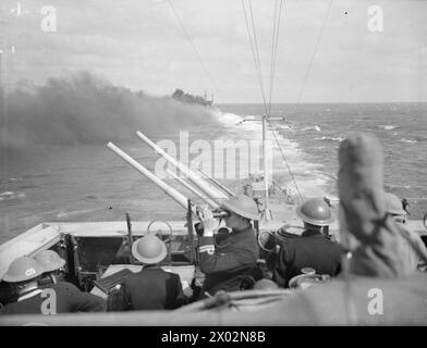 IL CONVOGLIO DA ALESSANDRIA A MALTA INCONTRA E INGAGGIA LE NAVI DA GUERRA ITALIANE. 22 MARZO 1942, A BORDO DELLA HMS EURYALUS. - La HMS CLEOPATRA fuma che controlla il convoglio visto dalla HMS EURYALUS Foto Stock