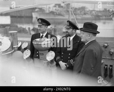 L'ALTO COMMISSARIO NEOZELANDESE VISITA CORVETTE. 24 FEBBRAIO 1944, GREENOCK. L'ALTO COMMISSARIO NEOZELANDESE JORDAN HA FATTO VISITA ALLA NUOVA CLASSE DI FIORI DELLA NUOVA ZELANDA CORVETTE, HMNZS ARABIS. - Da sinistra a destra; Lieut C S Evans, il primo tenente, RNZNVR, di New Plymouth; Lieut CDR J H Seelye, RNZNVR, il comandante, di Dunedin, e il sig. Jordan, sul ponte DEGLI ARABI Foto Stock