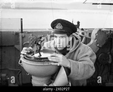 Il 3, 14 e 18 gennaio 1943, a bordo della HMS Malaya a Scapa Flow, i guardiamarina della Royal Navy praticavano abilità di navigazione, tra cui prendere direzione sul ponte. Foto Stock