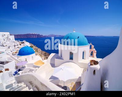 Le iconiche chiese a cupola blu della Resurrezione del Signore e di San Spyridon, il villaggio di Oia, l'isola di Santorini (Thira), le Cicladi, le isole greche, Grecia Foto Stock
