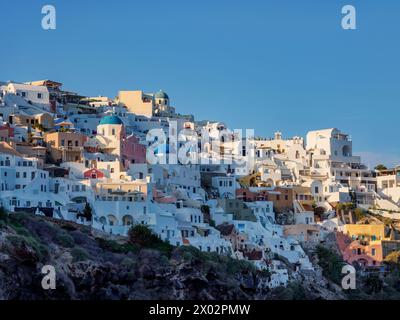 Ammira le chiese a cupola blu della Resurrezione del Signore e di San Spyridon al tramonto, il villaggio di Oia, l'isola di Santorini (Thira), le Cicladi Foto Stock