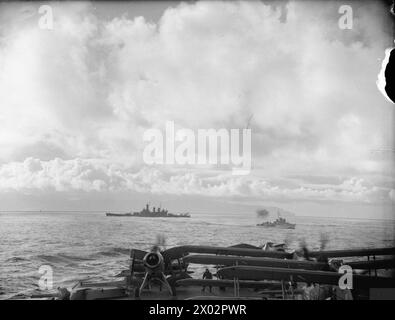 GLI AEREI E LE NAVI DA GUERRA INGLESI E STATUNITENSI COPRONO I CONVOGLI RUSSI. MAGGIO 1942, A BORDO DELLA HMS VICTORIOUS IN MARE E A HVALFJORD, ISLANDA. - Aerei sul ponte di volo della HMS VICTORIOUS Warming Up, sullo sfondo ci sono la corazzata statunitense USS WASHINGTON e un cacciatorpediniere della classe Hunt britannica Foto Stock