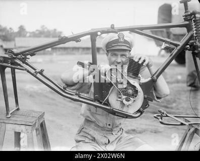 MOMENTI TROPICALI. 7 E 8 AGOSTO 1945, HMS RAJALYIA, ROYAL NAVAL AIR STATION PUTTALAM, CEYLON. ATTIVITÀ E PERSONALITÀ ALLA ROYAL NAVAL AIR STATION. - Il sottufficiale Jimmy Woodward di Chingford, ex autista di Trolleybus, che ripara la Despatch Riders Motor Cycles Foto Stock