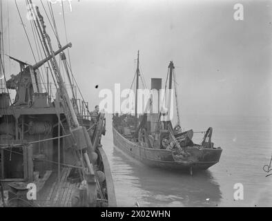 ATTACCO AL PESCHERECCIO STRATH BLARE. MARZO 1941. L'8 MARZO 1941, QUANDO LA STRATH BLARE ERA FUORI DALLA COSTA ORIENTALE DELLA SCOZIA, FU ATTACCATA DA UN BOMBARDIERE HEINKEL. L'EQUIPAGGIO FU COLTO DI SORPRESA QUANDO APPARVE PER LA PRIMA VOLTA E GIRÒ ATTORNO AL PESCHERECCIO. SI PRECIPITARONO VERSO LE PISTOLE, MA MENTRE SI TUFFAVA DI NUOVO PER MITRAGLIARE L'EQUIPAGGIO, UN'ALA COLPÌ L'ALBERO MIZZEN E SI SCHIANTÒ IN MARE. COSÌ FACENDO, PARTE DELL'ALA DI HEINKEL FU STRAPPATA E CIRCA 6 PIEDI DELL'ALBERO FURONO STRAPPATI VIA. QUANDO HA COLPITO L'ALBERO, SONO STATE SGANCIATE DUE BOMBE CHE SONO ATTERRATE SUL PONTE. QUI LA SQUADRA PER LO SMALTIMENTO DELLE BOMBE È VISIBILE Foto Stock