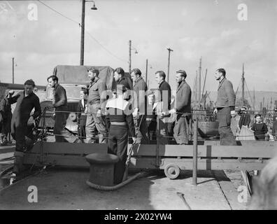 LA CORVETTE FRANCESE COMBATTE AFFONDA 2 U-BOOT. 14 MARZO 1943, GREENOCK, LA CORVETTE FRANCESE ACONIT AFFONDÒ DUE U-BOOT CON FUOCO A FUOCO E SPERONANDO MENTRE SCORTAVA UN CONVOGLIO ATLANTICO ATTRAVERSO L'U-BOOT PACK IL 10 MARZO 1943. IL SECONDO SOTTOMARINO AVEVA APPENA SILURATO IL BRITISH DESTROYER HMS HARVESTER. L'ACONIT GIUNSE IN UN PORTO BRITANNICO CON SOPRAVVISSUTI DEL MIETITORE E UN MERCANTILE, E PRIGIONIERI DEI DUE U-BOOT. - Prigionieri tedeschi di U-Boot che lasciano l'ACONIT FFS che li ha portati a bordo, dopo aver affondato i due sottomarini nemici Foto Stock