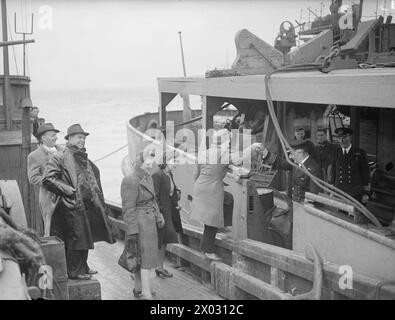 VAPORETTO CROSS CHANNEL ORA NAVE RICREATIVA PER I MARINAI. GIUGNO 1943, SCAPA FLOW. IL PIROSCAFO A VAPORE, AUTOCARRIER, UTILIZZATO PER IL TRASPORTO DI AUTO DA E PER LA FRANCIA, È OGGI UNA NAVE RICREATIVA PER GLI EQUIPAGGI DELLE NUMEROSE NAVI AUSILIARIE DELLA FLOTTA DOMESTICA CHE RISPONDONO ALLE ESIGENZE DI SERVIZIO DELLA ROYAL NAVY. E' IL PRIMO E UNICO NEL SUO GENERE, E PER MIGLIAIA DI UOMINI SIGNIFICA BIRRA E "FLICKS" UNA VOLTA ALLA SETTIMANA. - Il capitano W Baxter, capitano dell'AUTOCARRIER, dà il benvenuto a una festa dell'ENSA a bordo per uno spettacolo serale Foto Stock