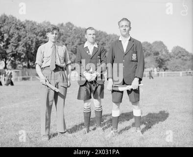 PARTITA DI FOOTBALL DELLA MARINA SUL CAMPO DI CALCIO GIOVANILE DI HITLER. MAGGIO 1945, KIEL. LA PARTITA DI CALCIO GIOCATA NELL'EX CAMPO SPORTIVO DEL MOVIMENTO GIOVANILE HITLER TRA IL NAVAL PARTY 1734 (BASATO SULLA NAVE AMMIRAGLIA) E LA 30A UNITÀ D'ASSALTO DELLA ROYAL MARINE E DELLA ROYAL NAVY COMMANDOS, CHE HA VINTO 4-3. I CIVILI TEDESCHI, GIOVANI E VECCHI, SI SONO ACCORSI PER VEDERE IL GIOCO E PER ASCOLTARE LA BANDA DI PIPA DEI CAMERONIANS, MA NON C'È STATA ALCUNA FRATERNIZZAZIONE. - Officianti erano, da sinistra a destra: Linesman Marine Commando e Spicer, di Chesham, Bucks; arbitro Lieut CDR F G Davis, RNVR, di Ilford; e Linesman Sub Lieut Merideth Foto Stock