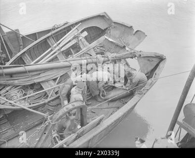 ATTACCO AL PESCHERECCIO STRATH BLARE. MARZO 1941. L'8 MARZO 1941, QUANDO LA STRATH BLARE ERA FUORI DALLA COSTA ORIENTALE DELLA SCOZIA, FU ATTACCATA DA UN BOMBARDIERE HEINKEL. L'EQUIPAGGIO FU COLTO DI SORPRESA QUANDO APPARVE PER LA PRIMA VOLTA E GIRÒ ATTORNO AL PESCHERECCIO. SI PRECIPITARONO VERSO LE PISTOLE, MA MENTRE SI TUFFAVA DI NUOVO PER MITRAGLIARE L'EQUIPAGGIO, UN'ALA COLPÌ L'ALBERO MIZZEN E SI SCHIANTÒ IN MARE. COSÌ FACENDO, PARTE DELL'ALA DI HEINKEL FU STRAPPATA E CIRCA 6 PIEDI DELL'ALBERO FURONO STRAPPATI VIA. QUANDO HA COLPITO L'ALBERO, SONO STATE SGANCIATE DUE BOMBE CHE SONO ATTERRATE SUL PONTE. QUI LA SQUADRA PER LO SMALTIMENTO DELLE BOMBE È VISIBILE Foto Stock