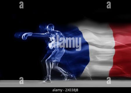 Giovane muscoloso, atleta di pugilato con guanti da allenamento pugni, pugilato su sfondo nero con elemento bandiera della Francia Foto Stock