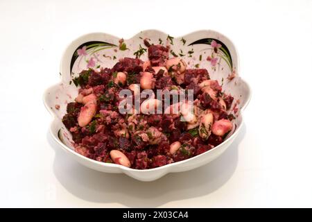 Un'insalata di verdure bollite, barbabietole, carote, patate, fagioli e tonno bollito si trova in un piatto profondo, vista dall'alto. Foto Stock