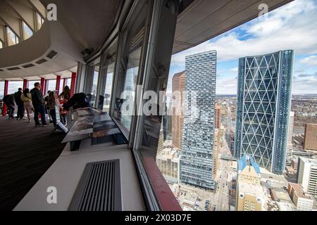 Calgary, Alberta Canada, 3 aprile 2024: Turisti che si affacciano sul paesaggio urbano del centro mentre camminano intorno al ponte panoramico della Calgary Tower. Foto Stock