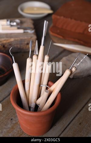 Set di diversi utensili per la lavorazione dell'argilla su un tavolo in legno in officina Foto Stock