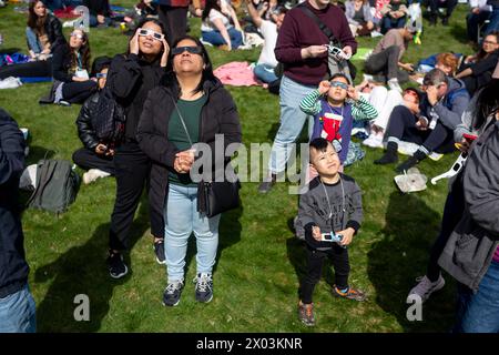 NEW YORK, NEW YORK - 8 APRILE: la gente si riunisce al Greenwood Cemetery di Brooklyn, a New York, durante un'eclissi solare parziale l'8 aprile 2024 a New York City. migliaia di persone si sono riunite in parchi e spazi aperti in tutta la città per vedere fino al 90% del sole coperto dalla luna. (Foto di Michael Nigro/Sipa USA) Foto Stock