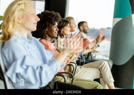 Una donna sorridente porta un applauso con i colleghi, condividendo un momento di gioia Foto Stock