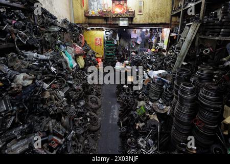 Un negozio di veicoli pieno di vecchie parti e attrezzi, l'atmosfera è caotica e disorganizzata, Chinatown di Bangkok, Thailandia Foto Stock