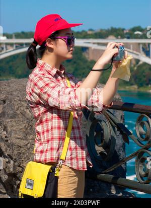 Donna asiatica che scatta foto a Niagra Falls Canada Foto Stock